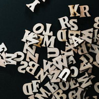 濃紺背景に散乱する木製アルファベットのパスワードの写真