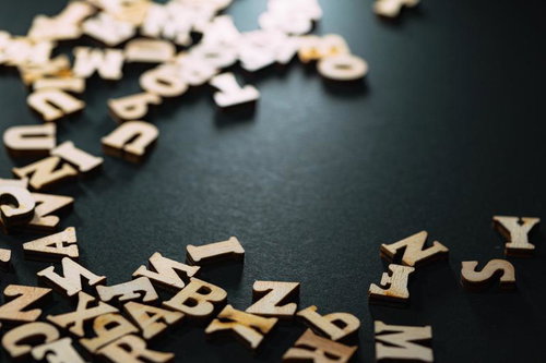 ダークグレーの背景にランダムに散らばるアルファベット文字