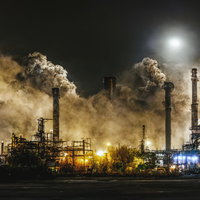 夜間に大量の煙を放出する工業プラント施設の排気と大気汚染の写真