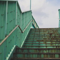 経年劣化で錆が目立つ歩道橋の階段と手すりの写真