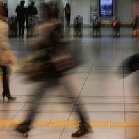 駅の改札前で行き交う通勤通学の人々と混雑風景の写真