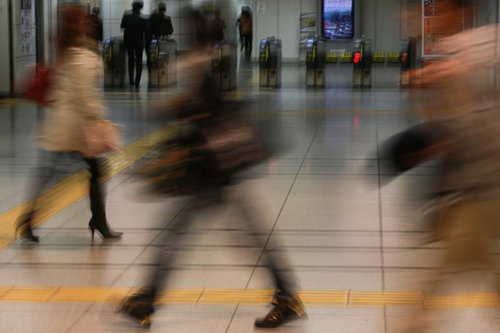 駅の改札前で行き交う通勤通学の人々と混雑風景