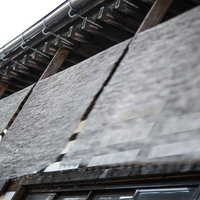 店先に掛かる和風のすだれと伝統建築の町並みの写真