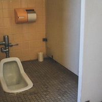 不気味な和式トイレの手洗い付き便所、昭和レトロなタイル壁の写真