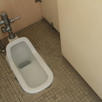 使われなくなった和式トイレの手洗い場と便器の写真