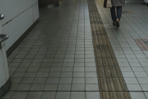 通路に敷かれた黄色い点字ブロックと誘導路