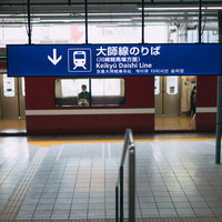 京急大師線のりばの駅ホームに停車する赤い車両の写真
