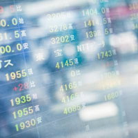 光が反射して見づらい株価チャートのモニターの写真