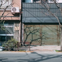 シャッターの下りた店舗の軒先と歩道の街並みの写真