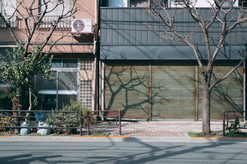シャッターの下りた店舗の軒先と歩道の街並み