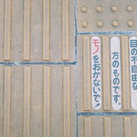 歩道に敷いた誘導ブロックと点字ブロックの写真