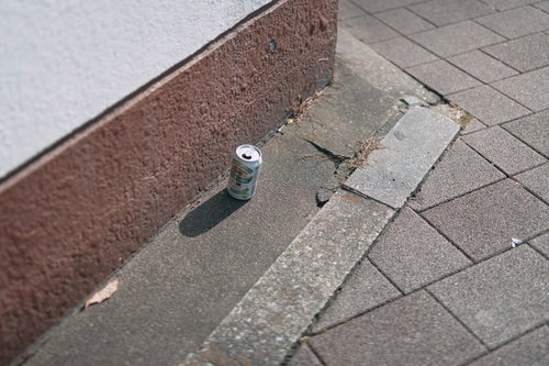 歩道に置き忘れられた白い空き缶とポイ捨て問題