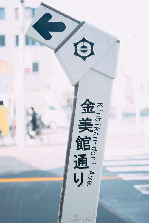金美館通りの指導標と矢印 白い案内板の道路標識