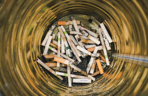 缶の灰皿に溜る大量のタバコの吸い殻と灰の状態