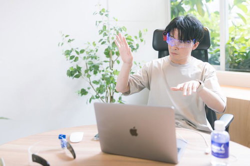 ARグラスを装着してジェスチャー操作するエンジニア男性