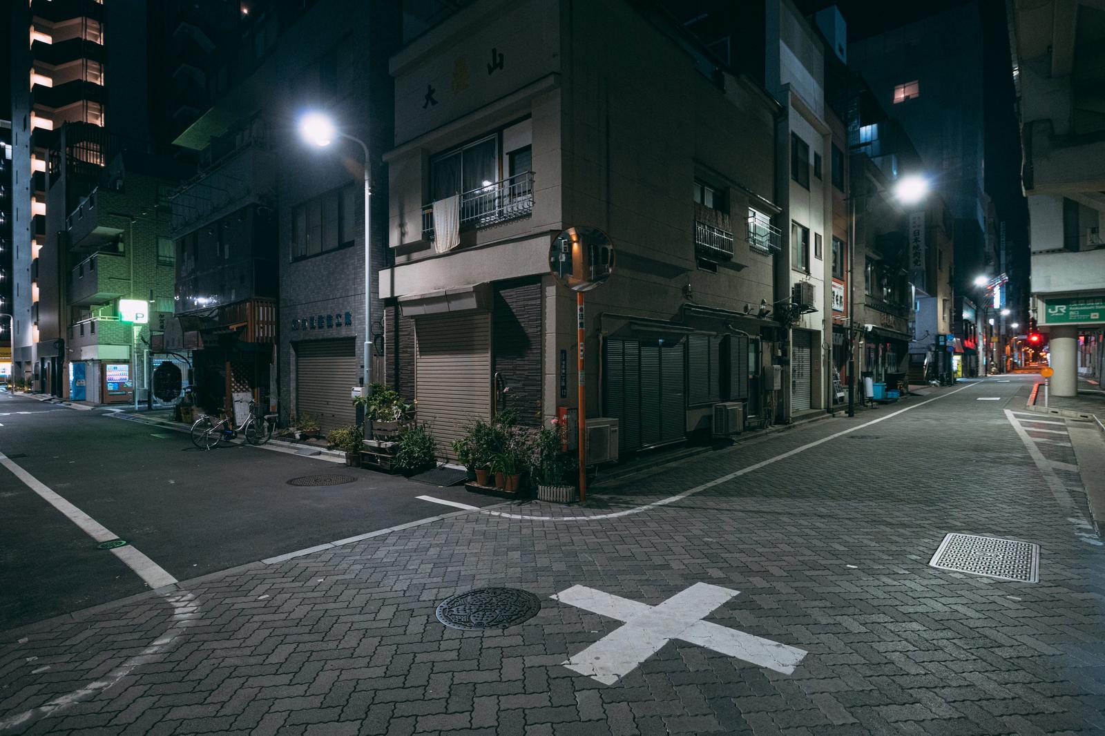 終電後の浅草橋駅前の静寂の住宅街。街灯の光に照らされた交差点に人影がない夜間風景