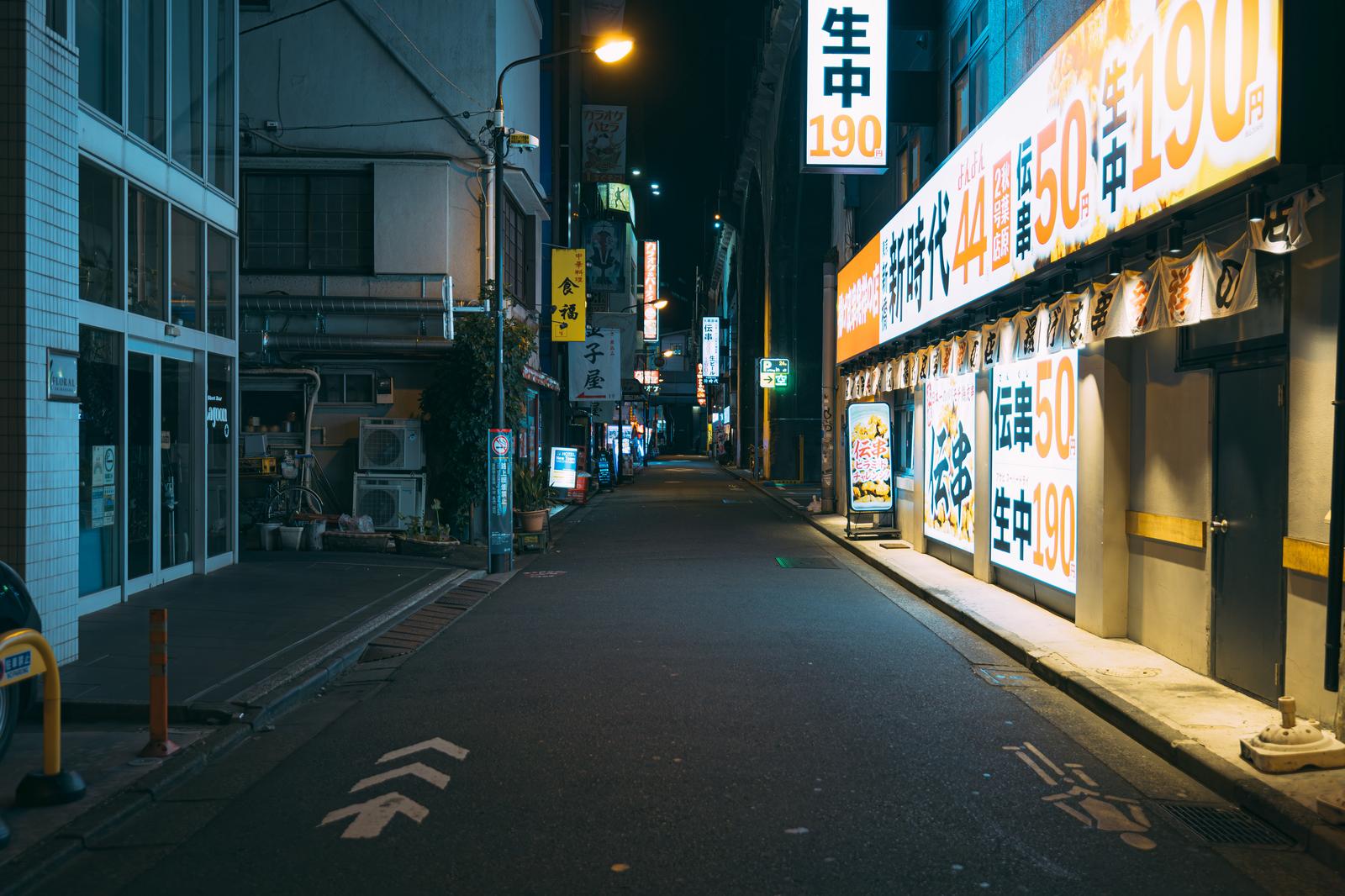 深夜の秋葉原神田の飲み屋街で、黄色い看板の居酒屋が立ち並ぶ夜景