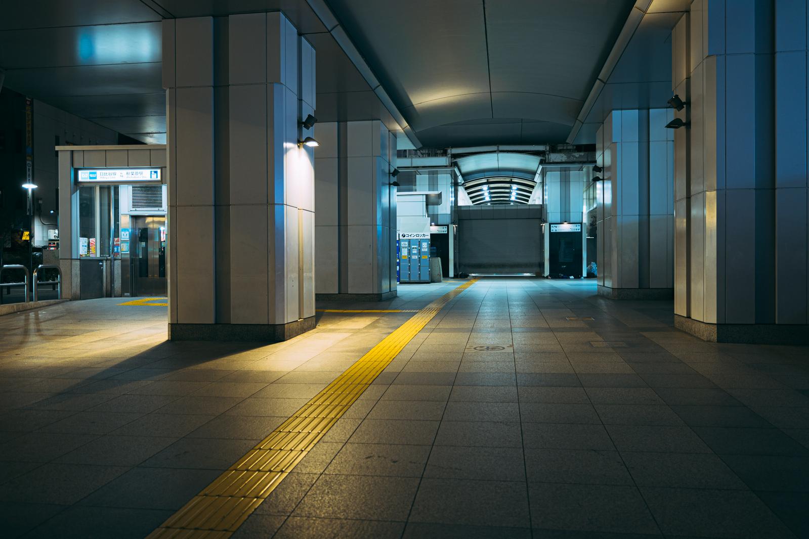シャッターが降りた秋葉原駅の夜間駅構内。点字ブロックが引かれた無人の通路