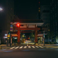 夜間の増上寺大門と都市風景、赤い柱と瓦屋根が街灯に照らされた東京の古寺社建築の写真