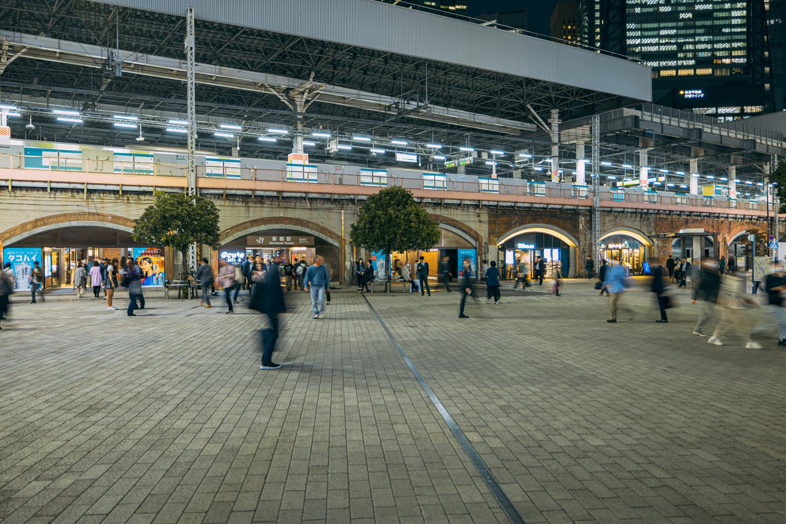 JR新橋駅前のSL広場で行き交う多くの人びとと駅舎