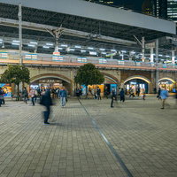 JR新橋駅前のSL広場で行き交う人びと、夕方から夜間の駅前風景の写真