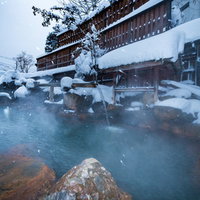 雪に覆われた露天風呂と平湯館の冬の露天風呂体験の写真