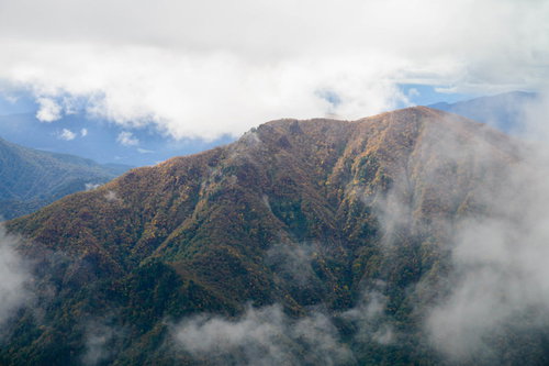 雲がかかる谷川連峰の秋の紅葉風景