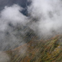 雲がかかる紅葉の谷川岳の秋の登山風景と紅葉狩りの写真
