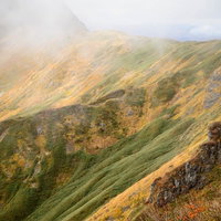 沸き立つガスと黄葉する秋の谷川岳の山岳風景の写真