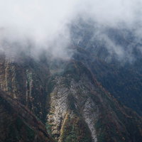 秋のモヤがかかる谷川岳の岩壁と稜線、険しい山肌の写真