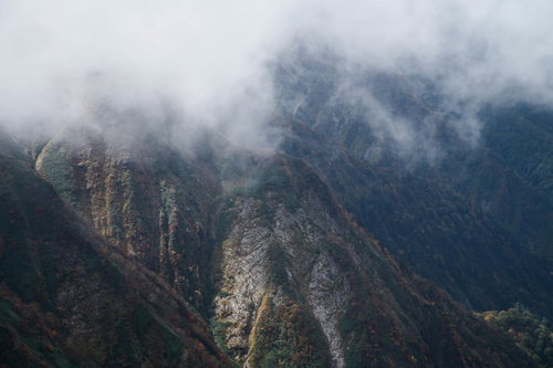 秋のモヤがかかる谷川岳の岩壁と稜線、険しい山肌