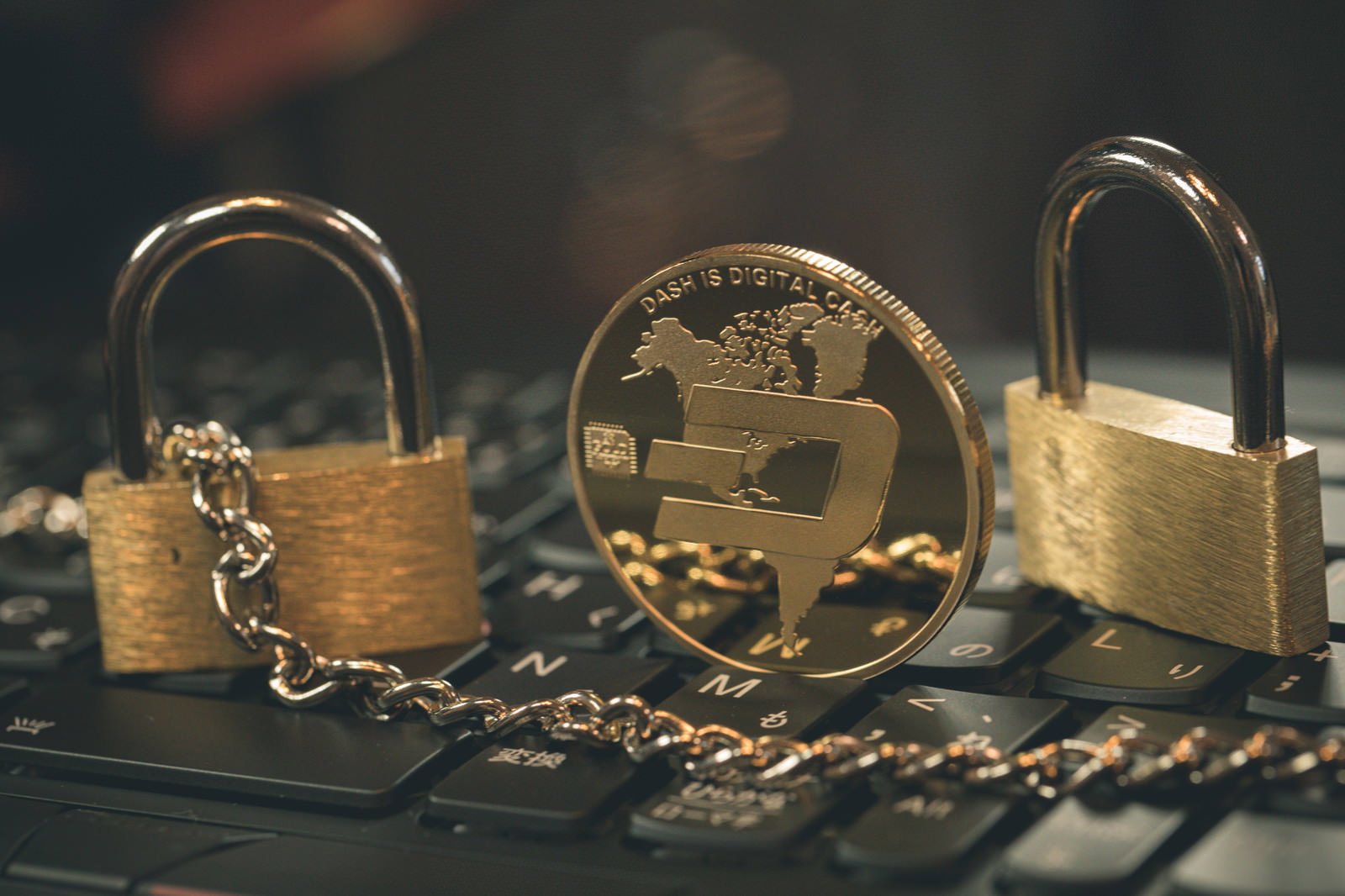 仮想通貨DASHのコインと金色の南京錠が鎖と共に並んでいる