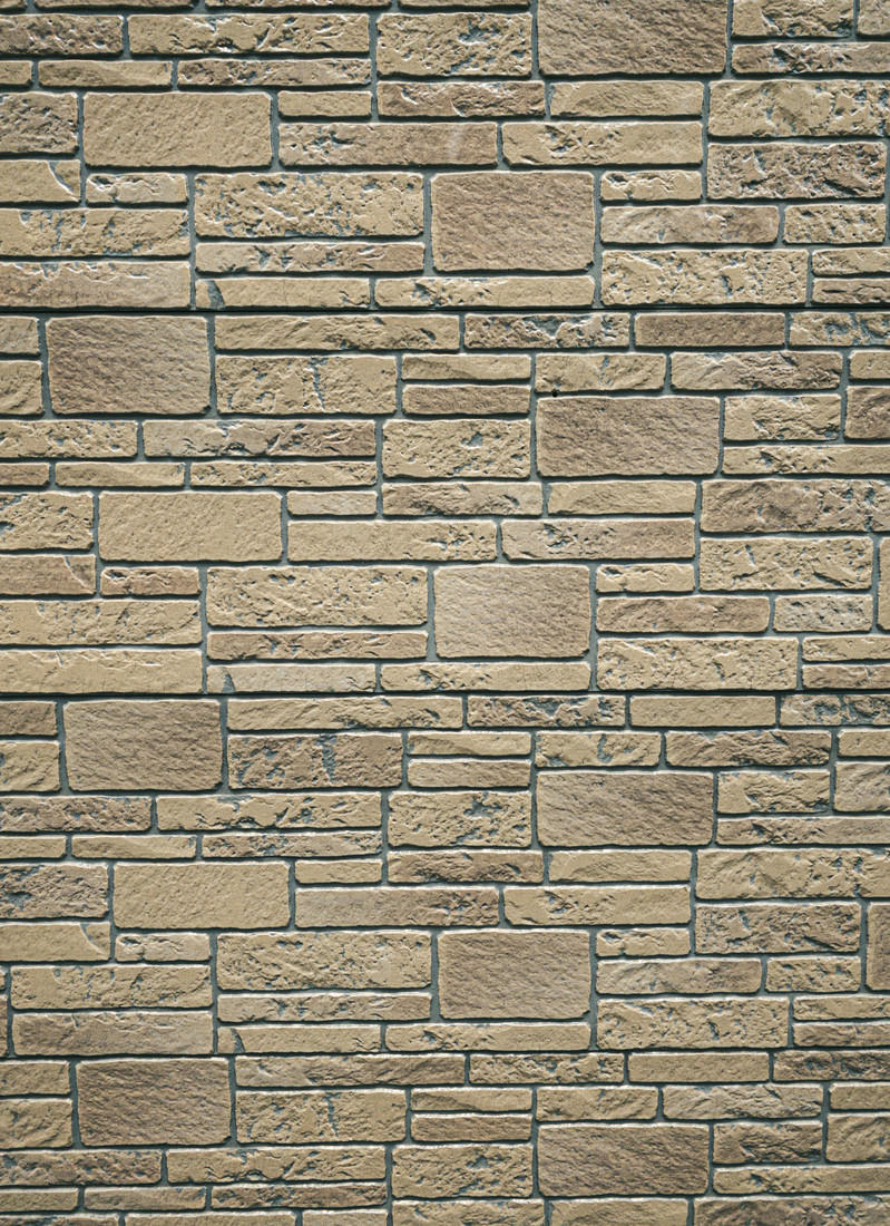 ベージュ色の長方形タイルが規則的に並んだ壁のテクスチャー