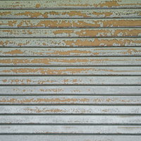 塗装がどんどん剥がれてきている錆びたシャッターの写真