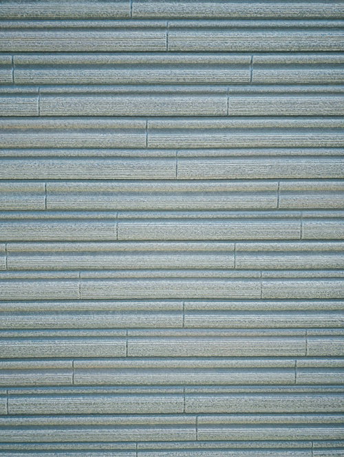 横に細かい線模様の入ったグレー金属シャッターのテクスチャー