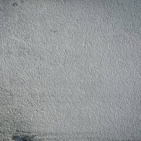 薄暗いグレーのモルタル壁のテクスチャーの写真