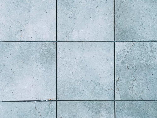 ひび割れが残ったグレーの正方形石材タイル