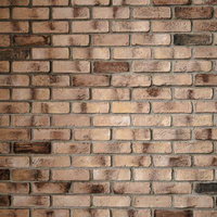 濃い色のレンガが混じる古い壁のテクスチャーの写真