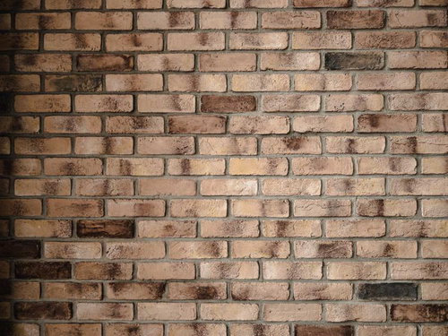 濃い色のレンガが混じる古い壁のテクスチャー