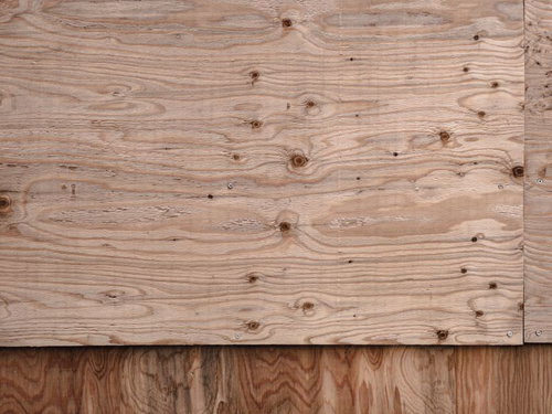 壁に張られたベニア板の木目テクスチャーと釘