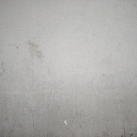 経年劣化で汚れたグレーのモルタル壁のテクスチャーの写真