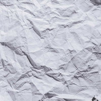 白い画用紙をくしゃくしゃにしわくちゃに丸めた状態の写真