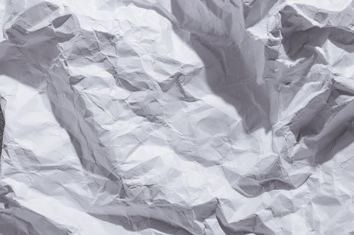 シワの数が多い白い画用紙のテクスチャー