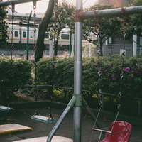 台東区立鶯谷公園のブランコと電車が見える線路風景の写真