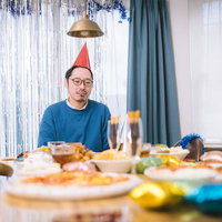 賑やかな食卓を前に物思いにふける冬の休日の写真