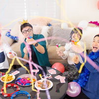 パーティールームで盛り上がるクラッカーと男女による誕生日パーティーの写真