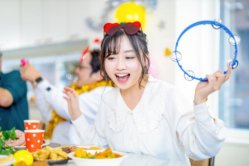 ホームパーティーでタンバリンを鳴らしてノリノリの女性