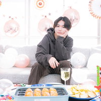 推しに見つめられながらタコパしてる男性のポスター付き部屋の写真