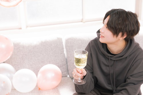 シュワシュワ片手にソファーに座る彼氏とお祝い