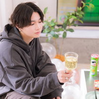 推しの彼とホームパーティーを過ごす、グレーのパーカー姿でくつろぐ男性の写真